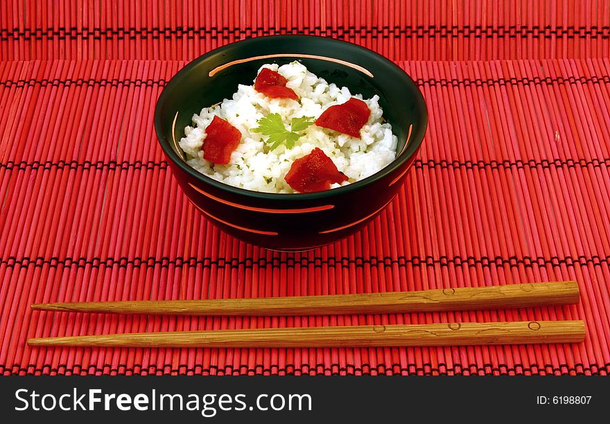 Chinese food in a black plate and sticks