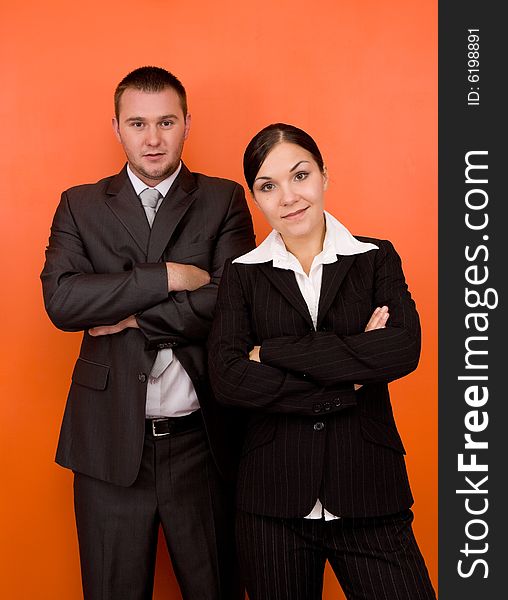 Businesswoman and businessman in team standing on orange background. Businesswoman and businessman in team standing on orange background