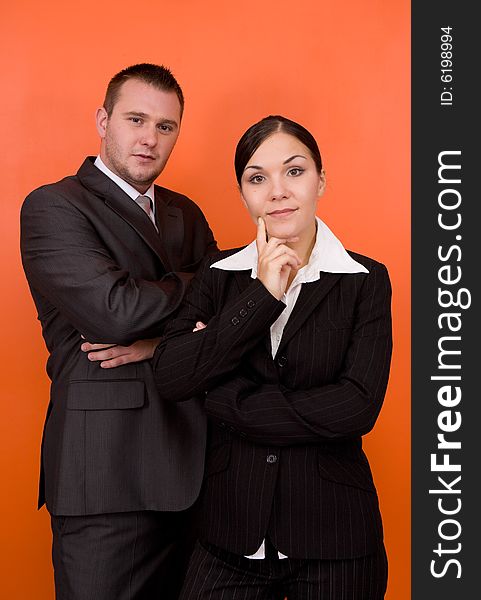 Businesswoman and businessman in team standing on orange background. Businesswoman and businessman in team standing on orange background