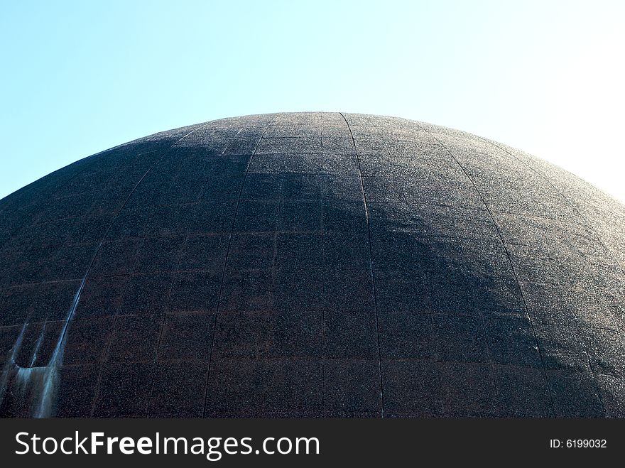 Large cement dome half in sunshine against a pale sky