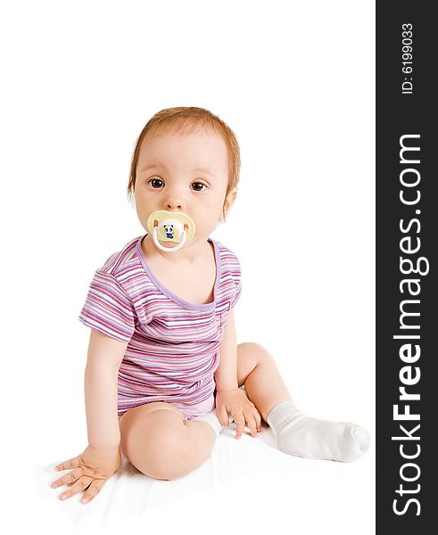 Little girl with pacifier sitting on white background