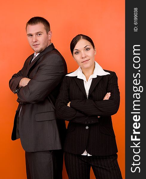 Businesswoman and businessman in team standing on orange background. Businesswoman and businessman in team standing on orange background