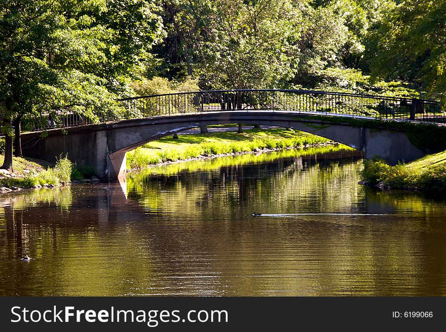 Scenic walking bridge arches over the charles river in boston massachusetts surrounded by trees. Scenic walking bridge arches over the charles river in boston massachusetts surrounded by trees