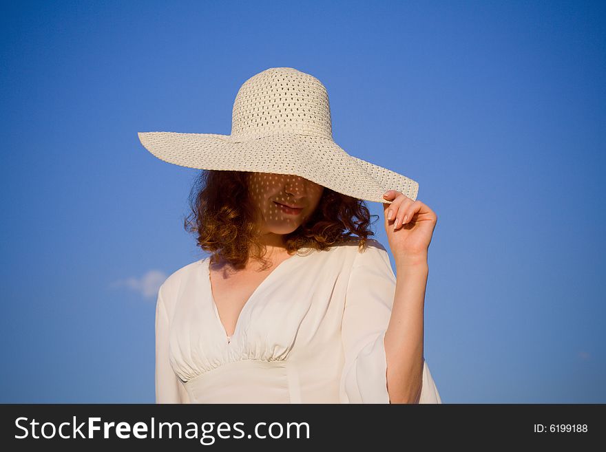 Girl dressed in hat on blue sky