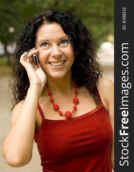 Outdoor portrait of pretty woman using mobile phone, smiling