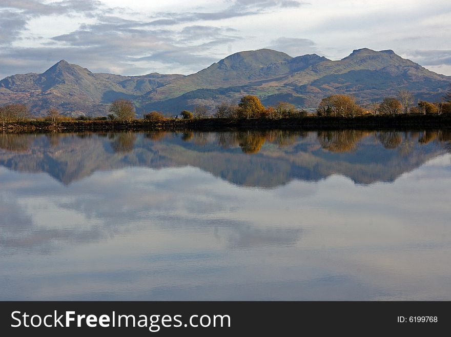 Mount Snowdon in Wales, reflecting in a lake