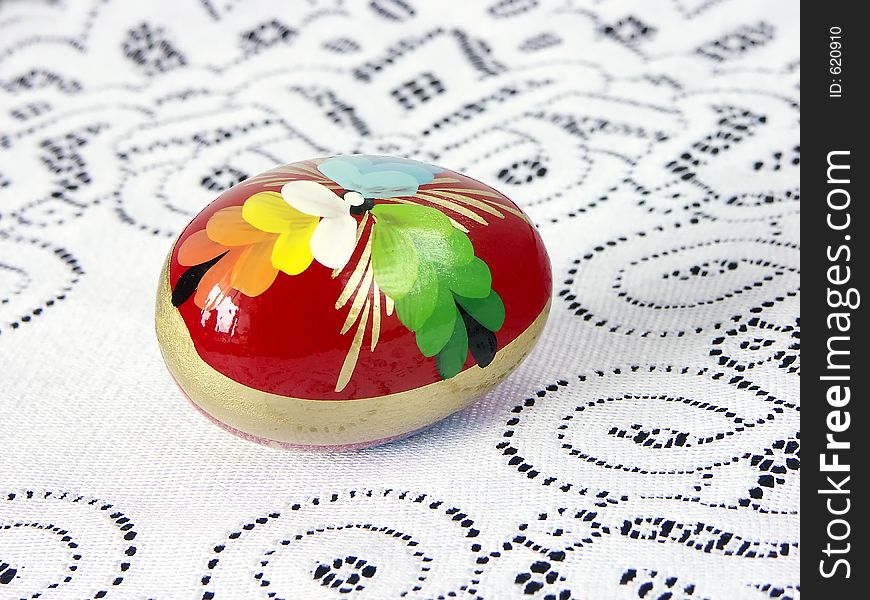 Painted easter egg on white knitted tablecloth. Painted easter egg on white knitted tablecloth