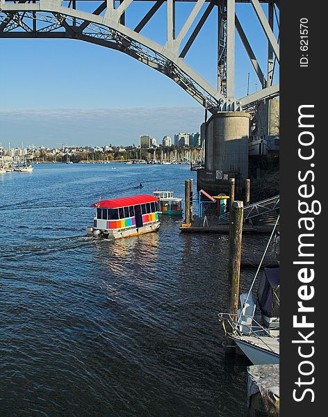 Small ferry under bridge