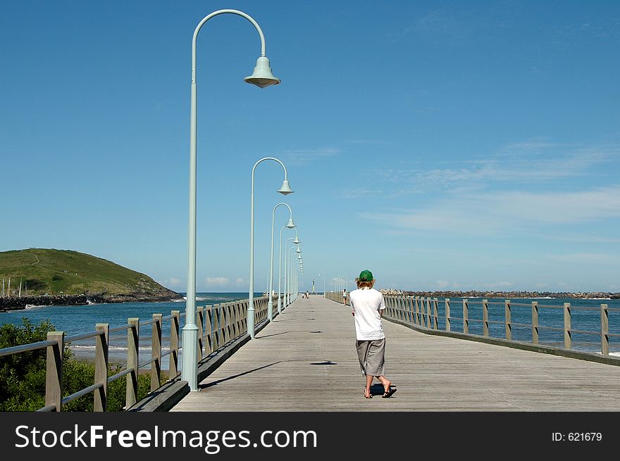 Man standing on a pier looking out to sea in Australia