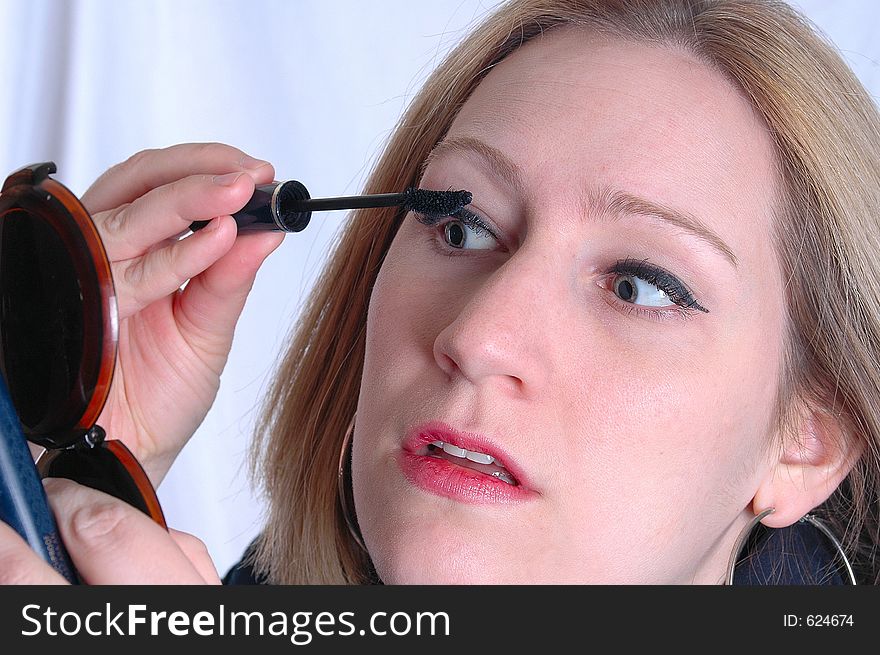 A woman applying mascara. A woman applying mascara.