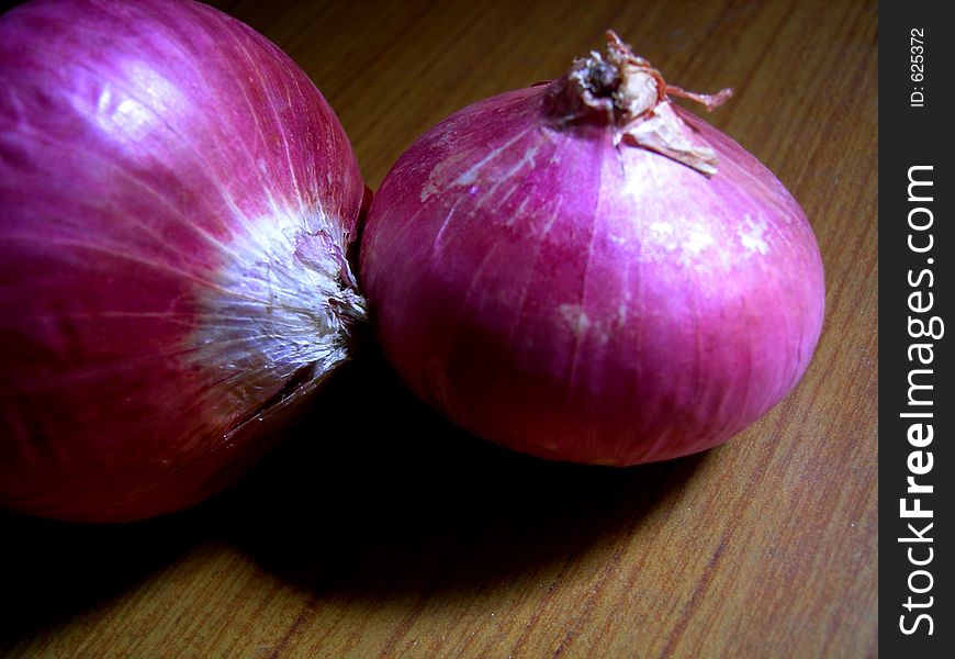 A close shot of onions lying on the kitchen tabel.