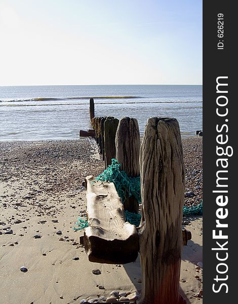 Wooden post running along beach