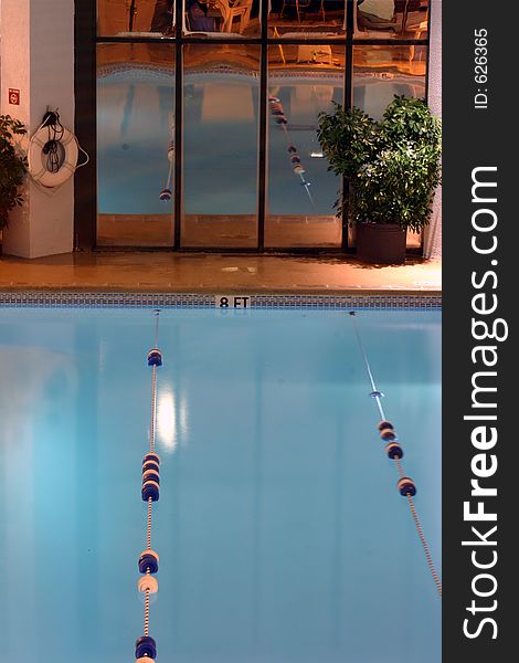 The deep end of the hotel pool with the rest of the pool reflected in the mirror windows. The deep end of the hotel pool with the rest of the pool reflected in the mirror windows