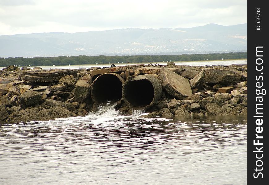 As the tide lowers, the flats drain of water. These two pipes allow water into a boat channel. As the tide lowers, the flats drain of water. These two pipes allow water into a boat channel.