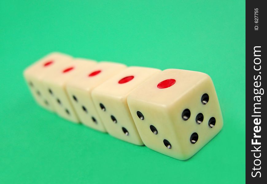 Perspective with five dice on green surface.Selective focus on the first die. Perspective with five dice on green surface.Selective focus on the first die.