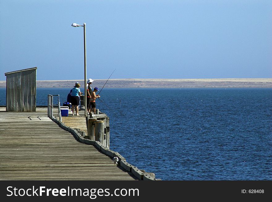 A family fishing off the end of the Pt. Victoria jetty, South Australia. A family fishing off the end of the Pt. Victoria jetty, South Australia.