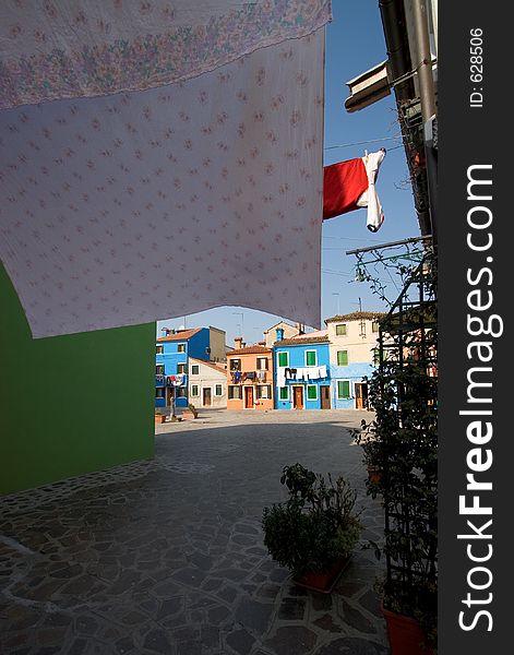 Sheets Drying in the sun in a typical square on the Venetian Island of Burano. This island is famous for it's colourful houses. Sheets Drying in the sun in a typical square on the Venetian Island of Burano. This island is famous for it's colourful houses