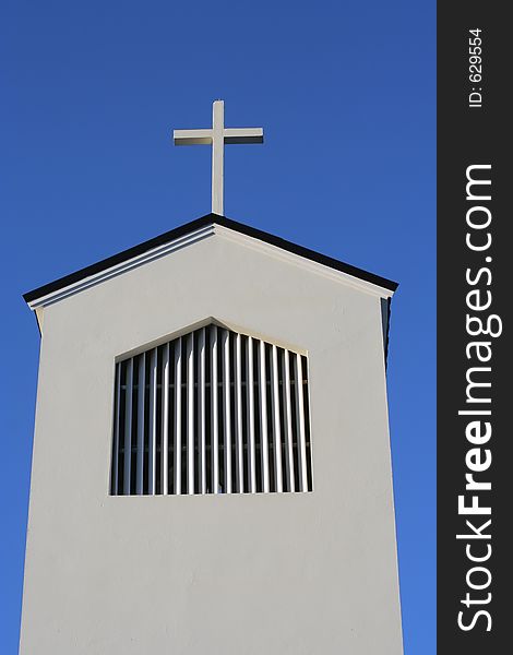 Cross and church roof against a blue sky