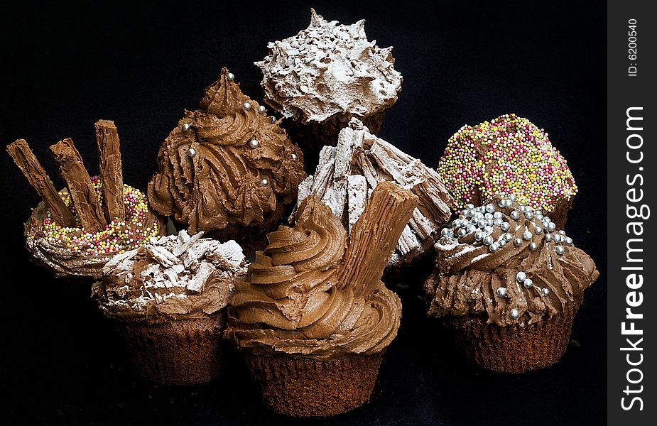 Cup cakes/Muffins suitable for a birthday card or celebration card.chocolate fondant icing and silver balls, icing sugar, flakes and sprinkles. Cup cakes/Muffins suitable for a birthday card or celebration card.chocolate fondant icing and silver balls, icing sugar, flakes and sprinkles