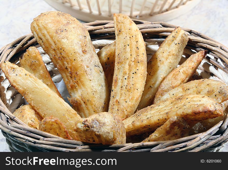 Close up of spicy potato wedges in a basket