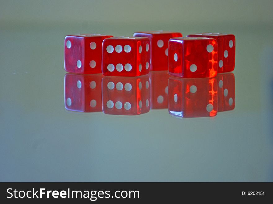 Five red cube to play on a glass table. Five red cube to play on a glass table