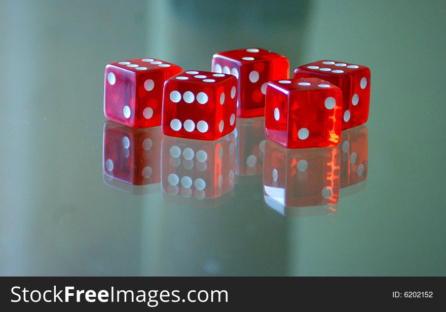 Five red cube to play on a glas table. Five red cube to play on a glas table.