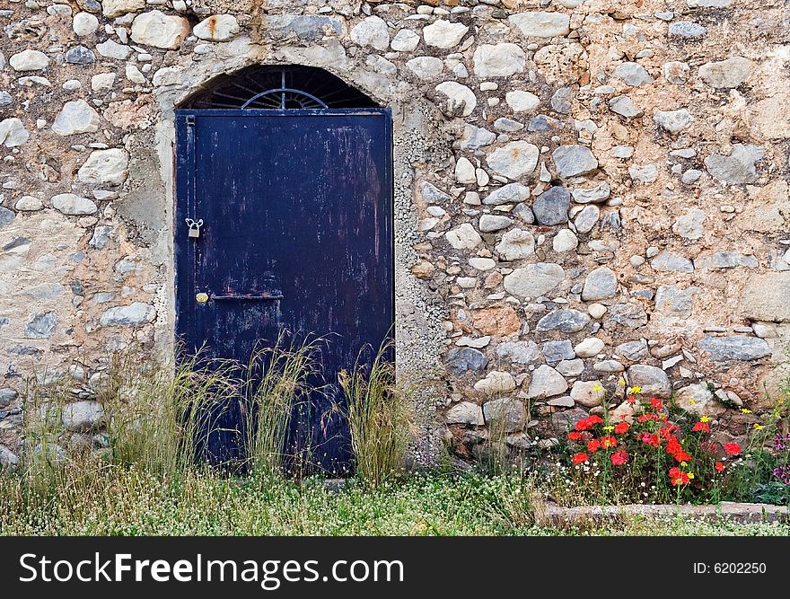 Picture of a blue metallic high texture door on a typical old stone building found in Mani, southern Greece. The flowers on the right balance the image nicely. Picture of a blue metallic high texture door on a typical old stone building found in Mani, southern Greece. The flowers on the right balance the image nicely