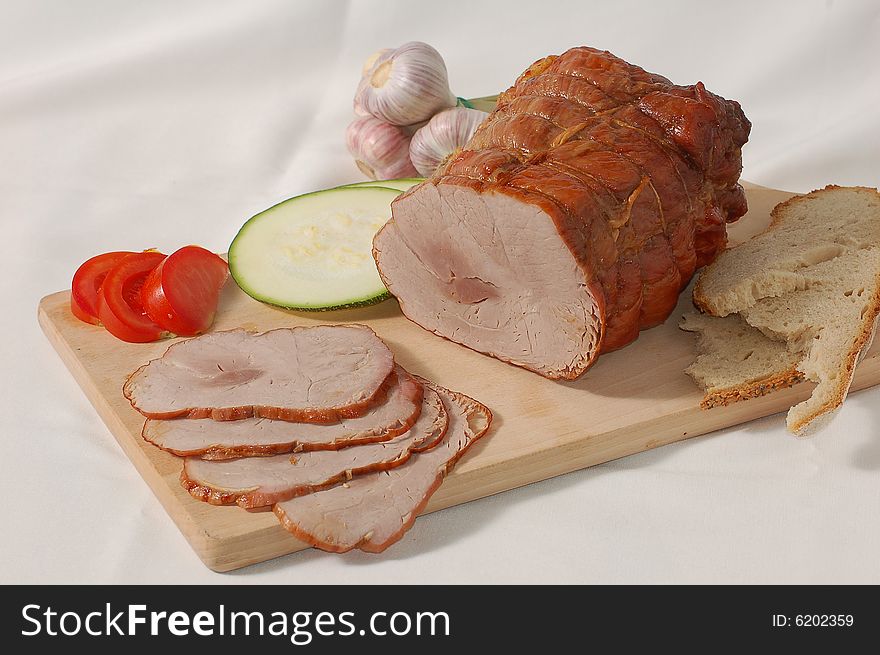 Ham with bread and vegetables on the bread-board