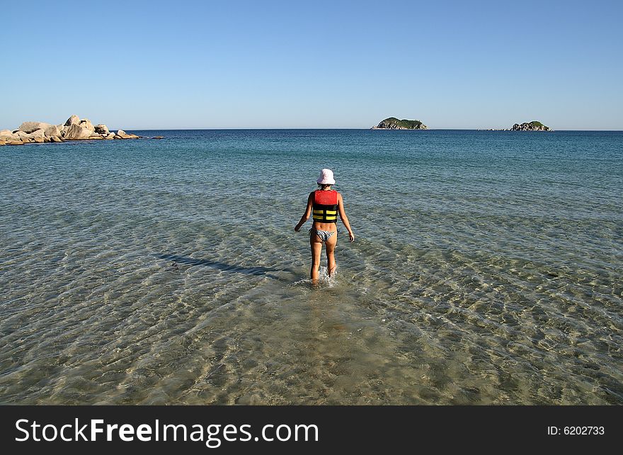 The young girl leaves in the evening sea