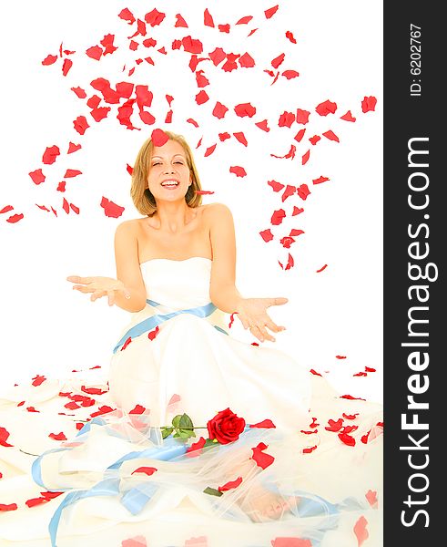 Happy beautiful caucasian bride in her gown sitting and receiving rose petal from above. Happy beautiful caucasian bride in her gown sitting and receiving rose petal from above