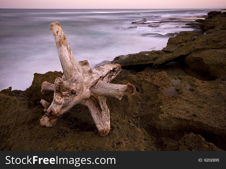 Seascape with rocks and white log in foreground. Seascape with rocks and white log in foreground