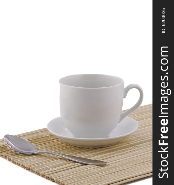 White cup on a bamboo napkin. White cup on a bamboo napkin