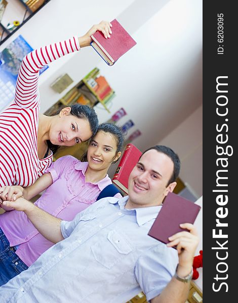 Three happy students in library. Three happy students in library