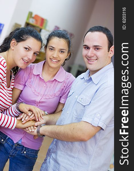 Three friends or students putting hands together. Three friends or students putting hands together