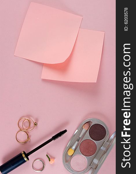 Cosmetics and paper. At pink background. The model for posting your pictures or inscriptions.