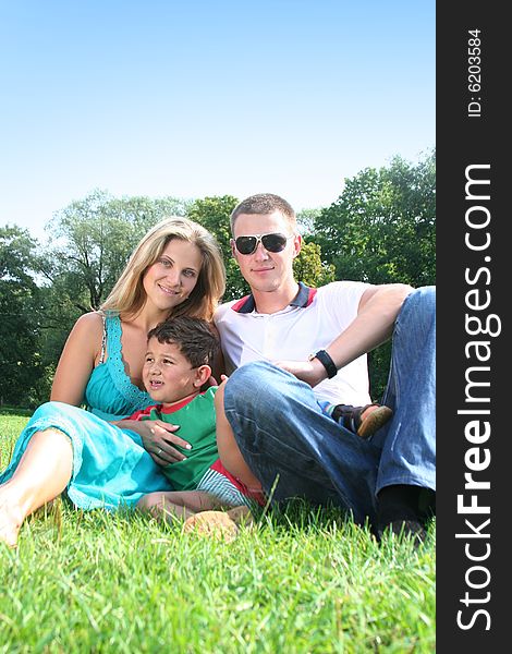 Happy family relaxing in park. Happy family relaxing in park