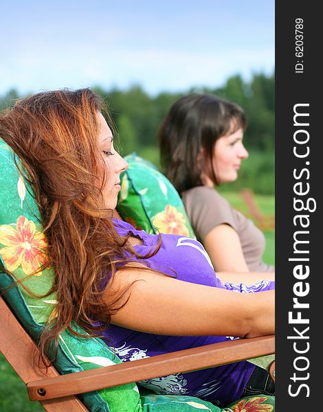 Two young girls relaxing outdoors. Two young girls relaxing outdoors