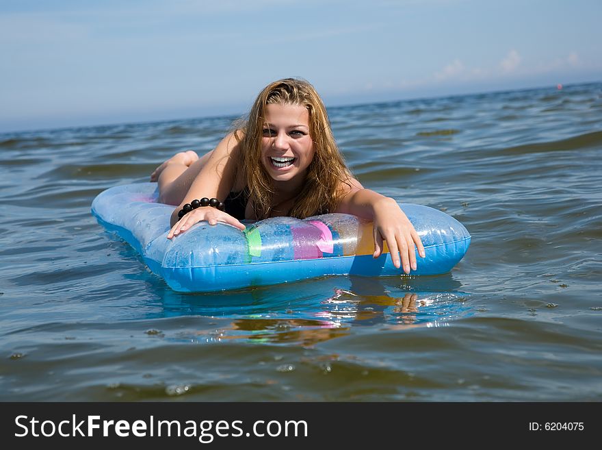 Beautiful girl swiming on air-mattress in sea. Beautiful girl swiming on air-mattress in sea