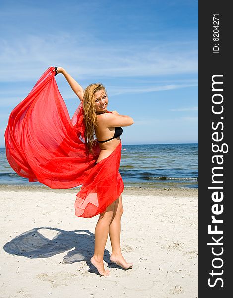 Beautiful girl with red shawl on beach. Beautiful girl with red shawl on beach