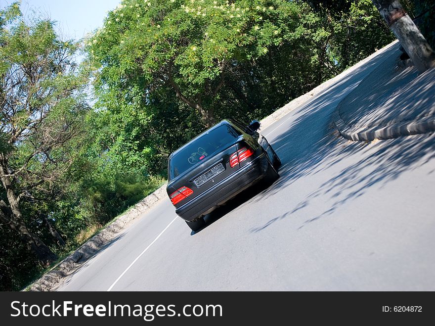 The black car goes in turn on the big speed. The black car goes in turn on the big speed