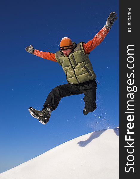 Young jumping man; flying; snow; clear sky