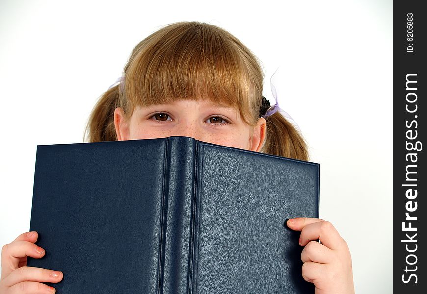 Pretty school girl hiding after notebook. Pretty school girl hiding after notebook