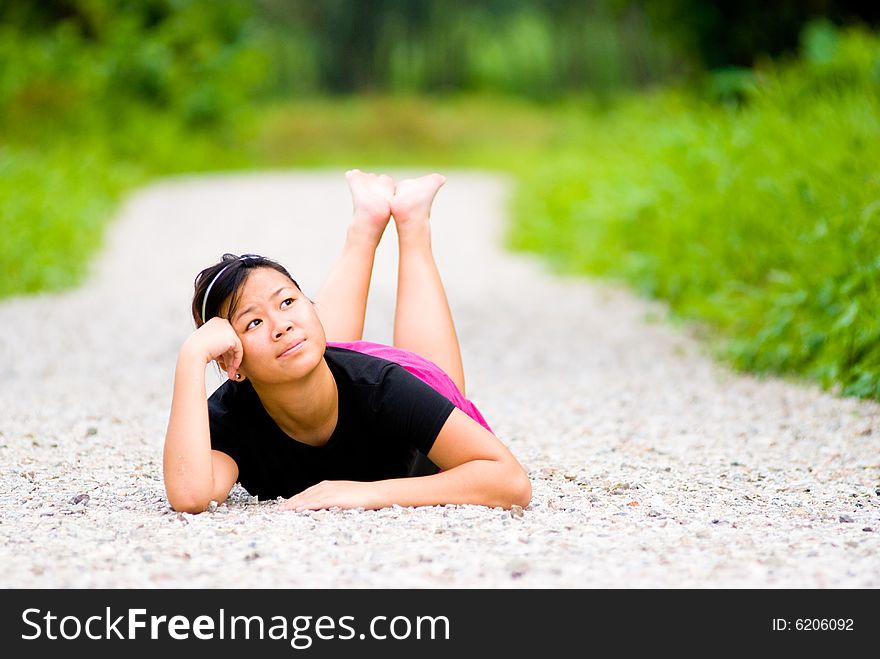 Barefooted girl reminiscing while sprawl on a foot trail. Barefooted girl reminiscing while sprawl on a foot trail