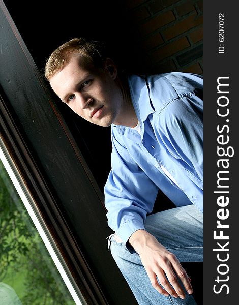 Natural light portrait of man at window - tilted for perspective. Natural light portrait of man at window - tilted for perspective