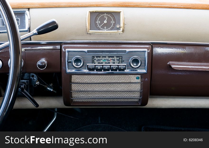 Old style steering wheel and dashboard. It can also be seen the gear lever on th esteering column, the old stereo, speaker and clock. Old style steering wheel and dashboard. It can also be seen the gear lever on th esteering column, the old stereo, speaker and clock.