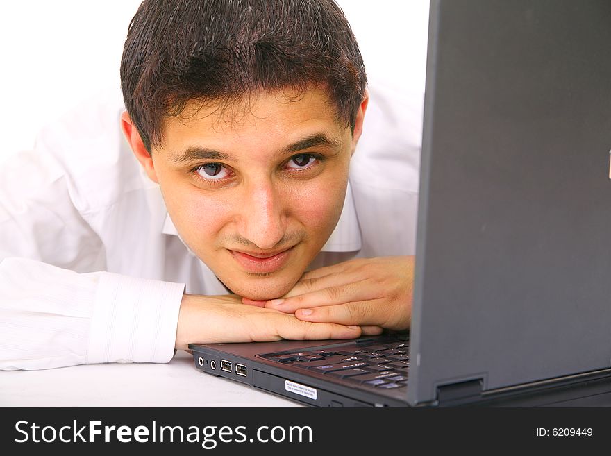 Young man looks away from laptop with smile. isolated on white background. Young man looks away from laptop with smile. isolated on white background