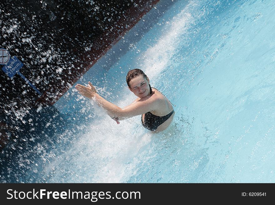 The girl under waterfall in a aquapark
