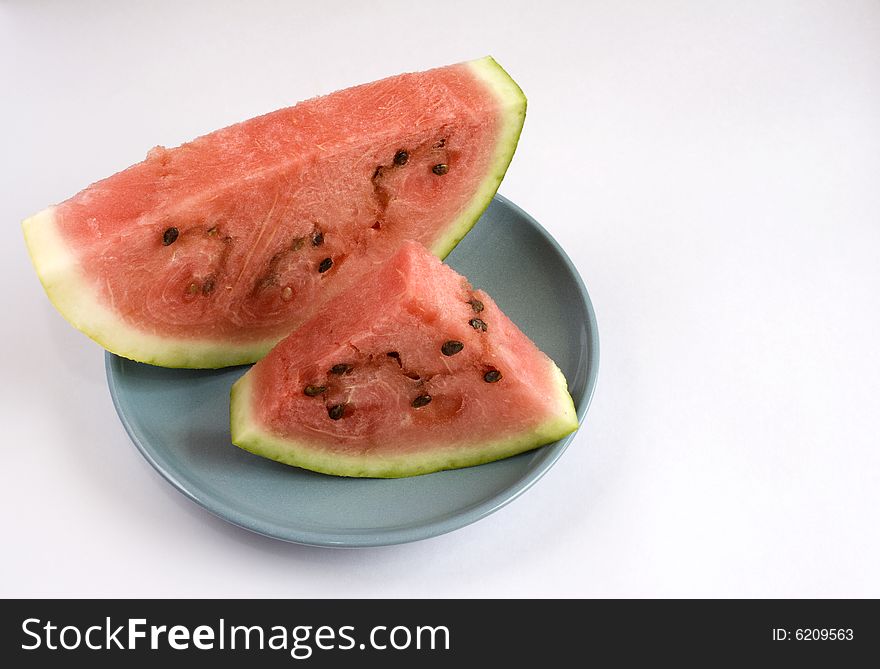 Appetizing slices of watermelon in a blue plate. Isolated on white background.