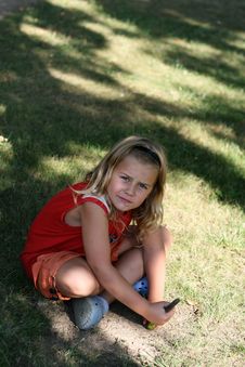 Child Sitting On The Grass Stock Photo