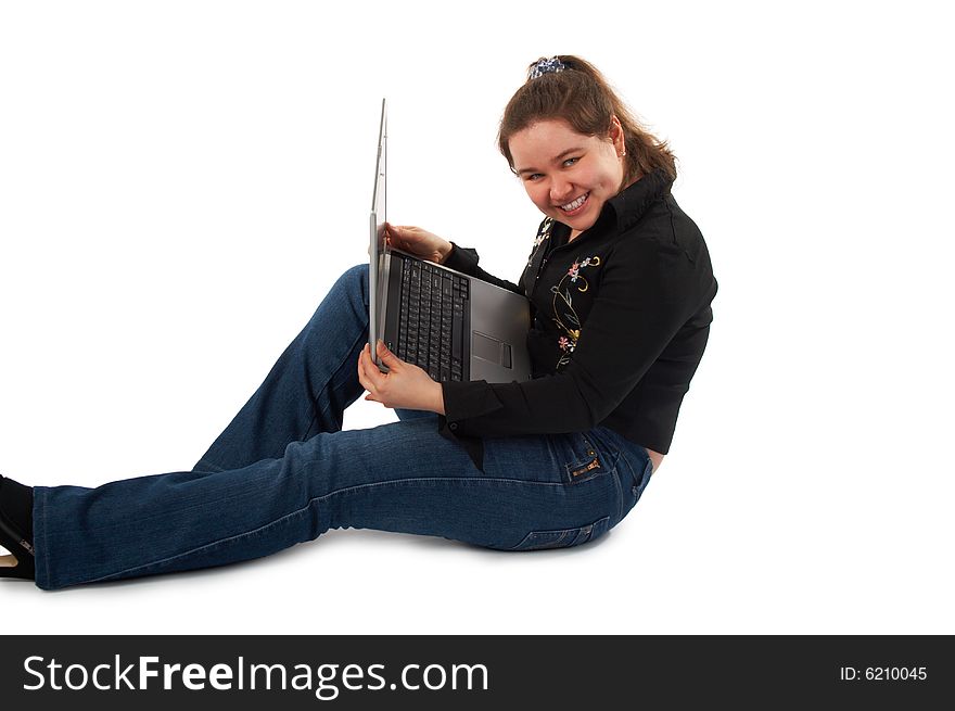 Girl with notebook sits on floor showing screen